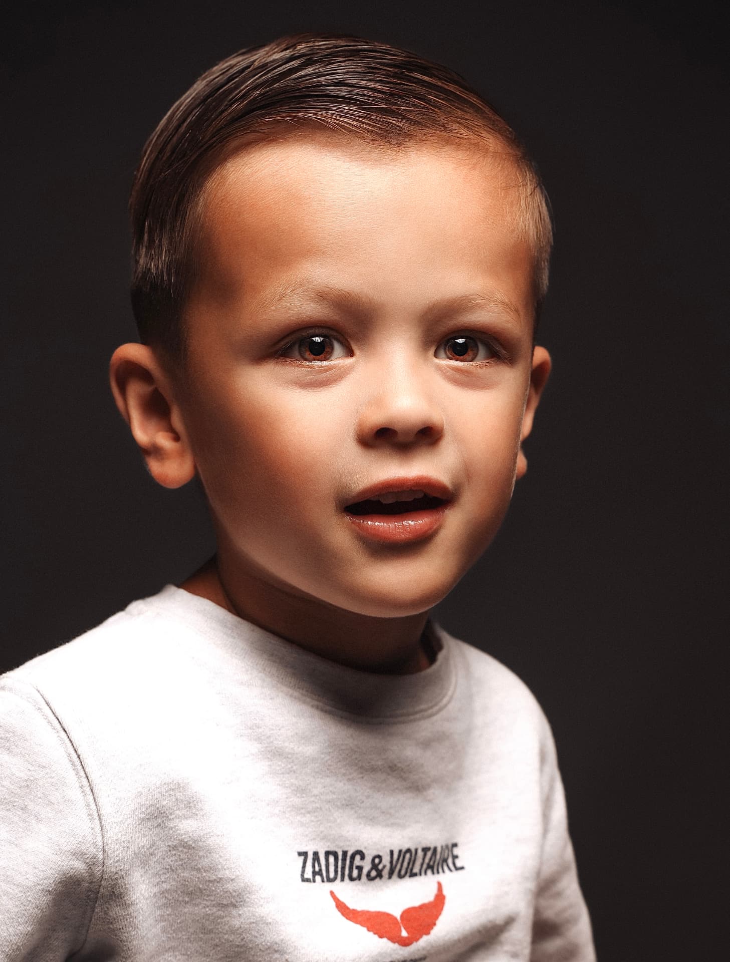 Portret van een jongen tegen een donkere achtergrond